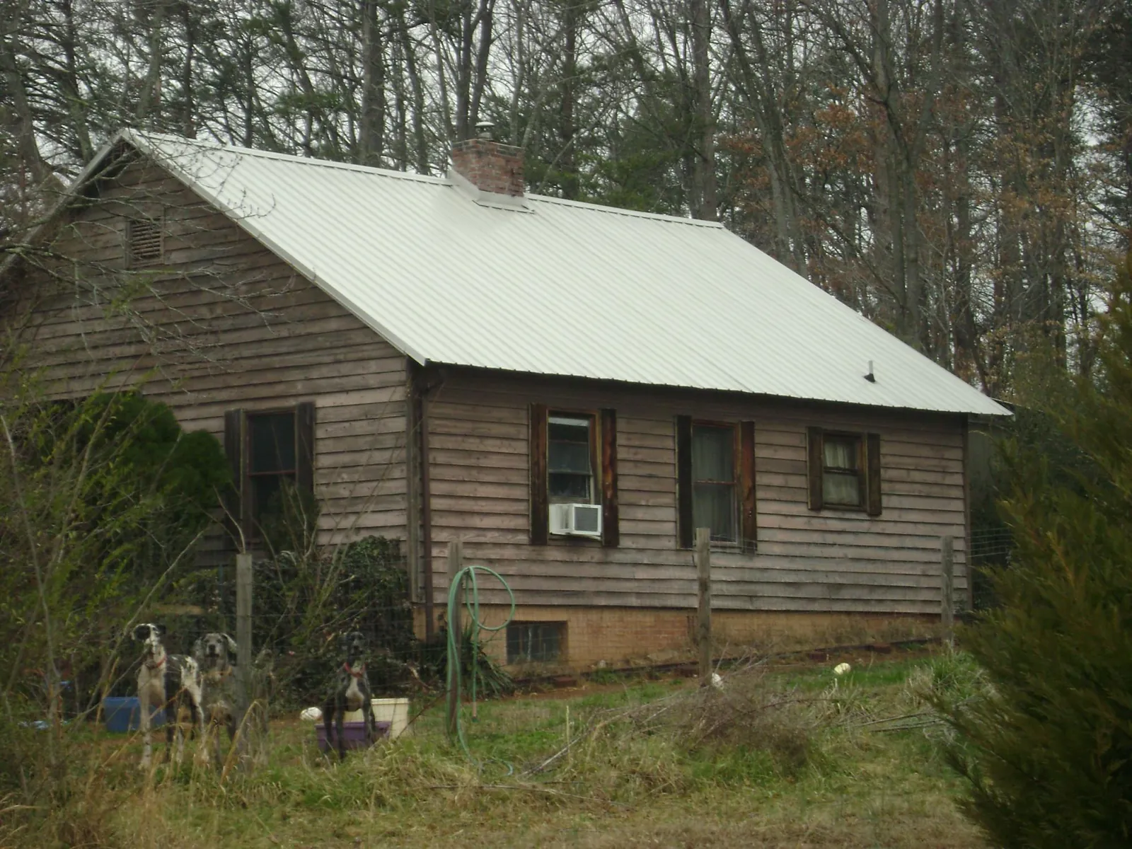 White metal roof on an old wood sided farmhouse, from a Metal Roof Installation job in Davenport